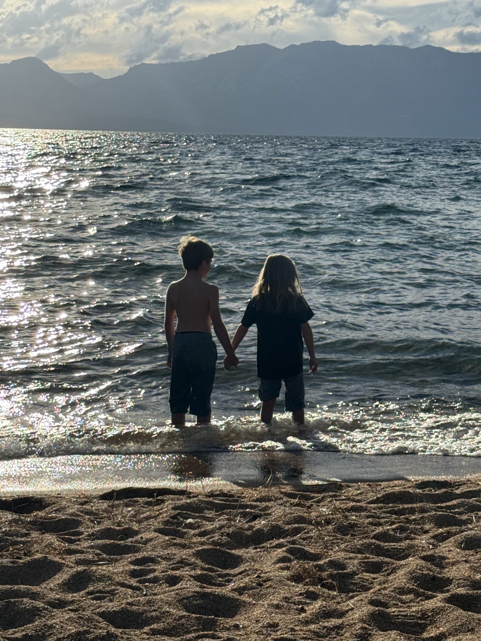 Two children looking towards the sunset at Lake Tahoe, the end of the Loneliest Road in America