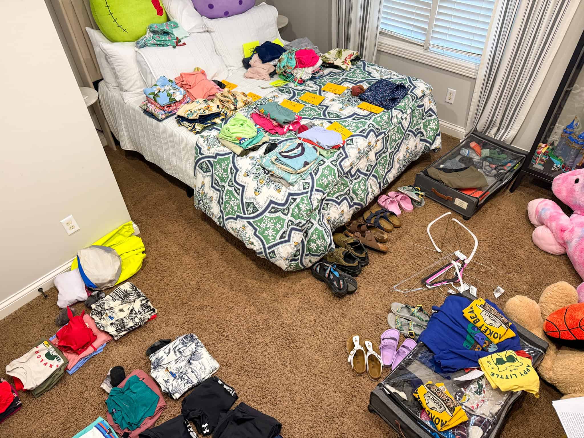 Family packing system laid out by day on bedroom floor with note cards