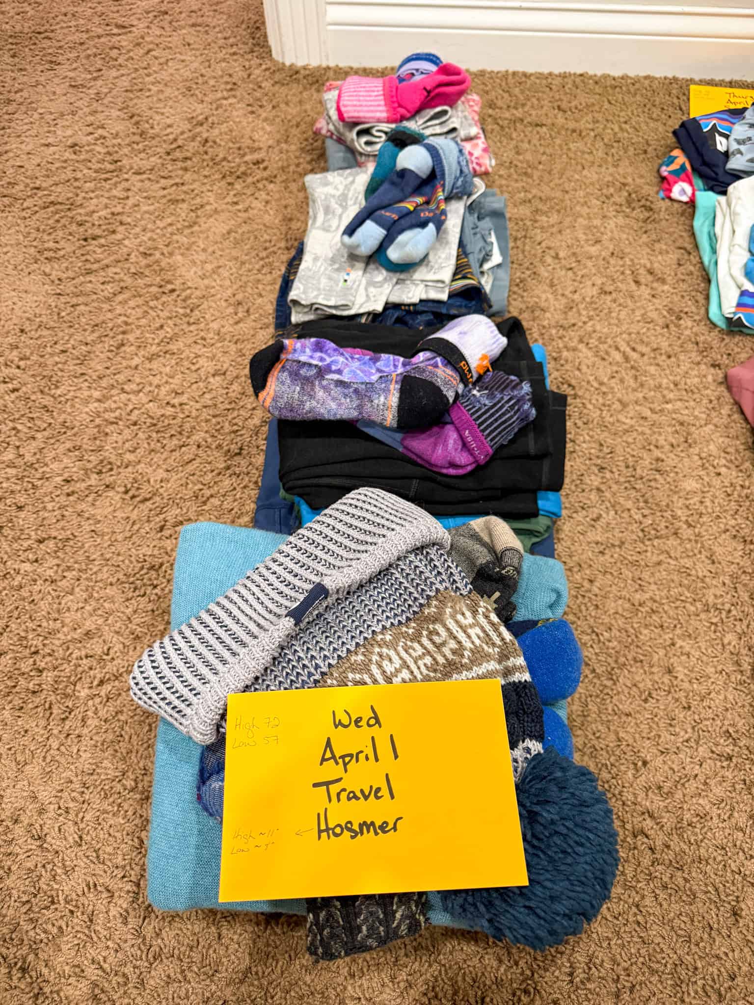 One day of clothes for four people packed together using day-by-day family packing system