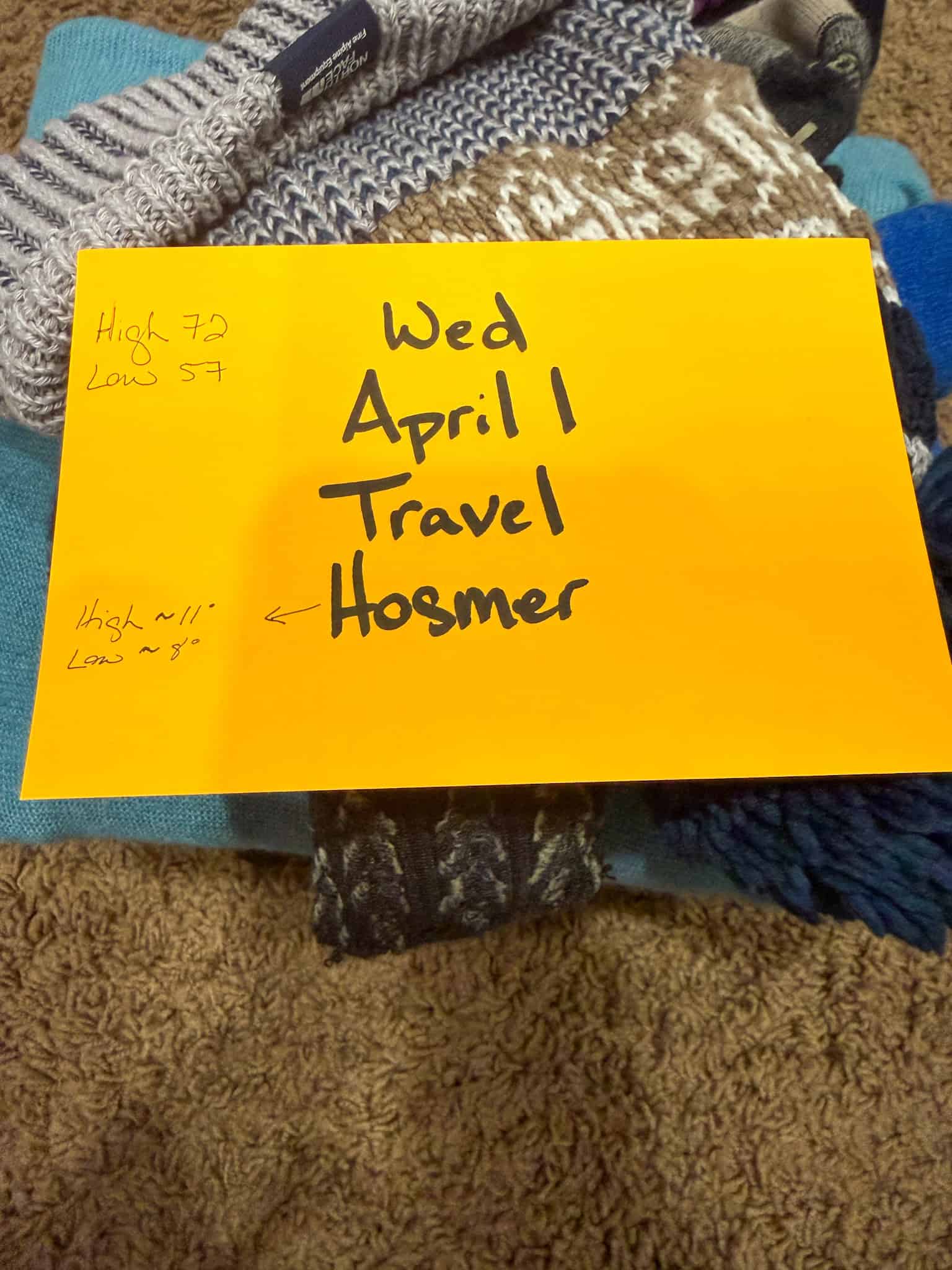 Day-by-day family packing system with note card showing date, activity, and weather
