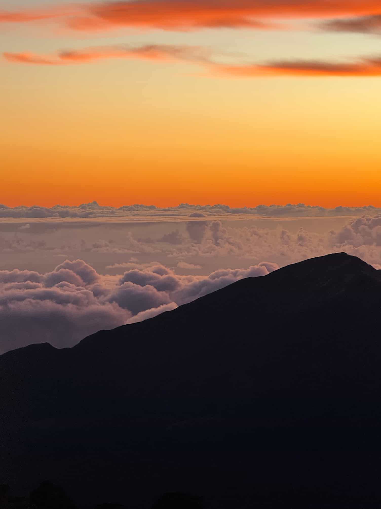 Sunrise above the clouds viewed from the summit of Haleakalā National Park at 10000 feet
